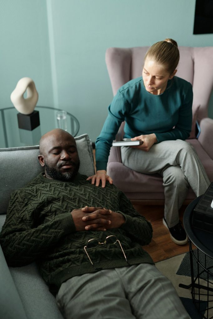 Therapy session with client laying down on a chair.
