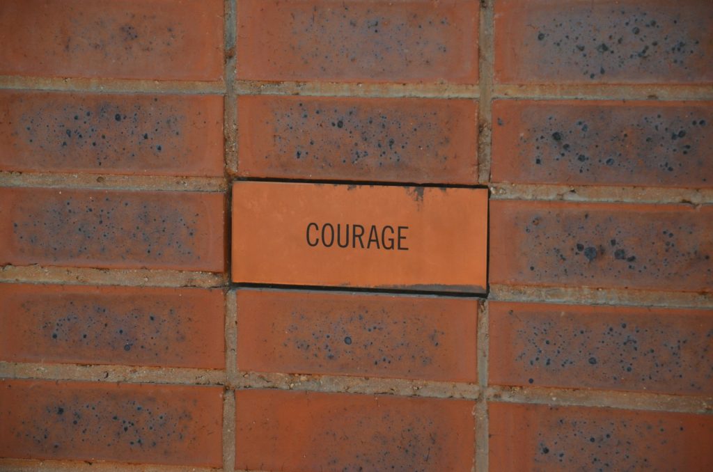Photograph of a brick containing the word courage