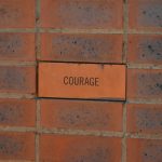 Photograph of a brick containing the word courage